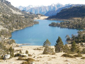 A lake surrounded by mountains and sparse vegetation. - Le Barbajou (Aragnouet)