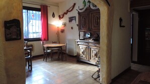 A dining area with a round table and chairs, a radiator, and wooden cabinets. - Le Barbajou (Aragnouet)