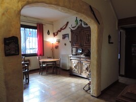 Un comedor con una mesa redonda y sillas, un radiador y armarios de madera.