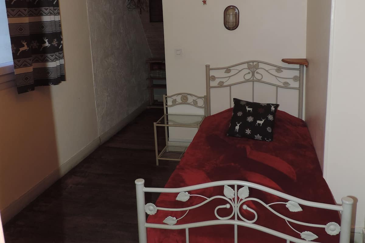 A bedroom with a bed, a mirror, and a wall decoration.
