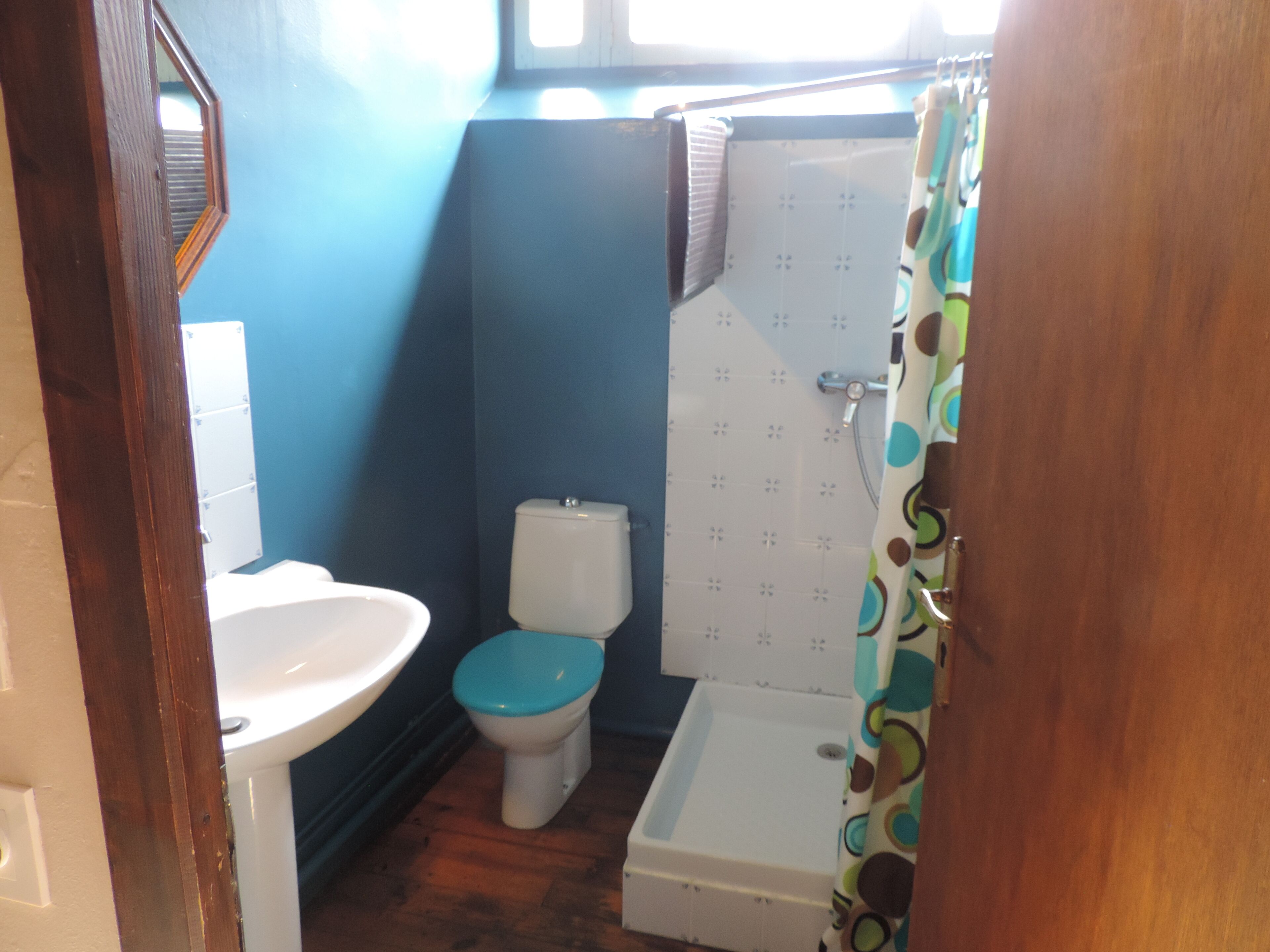 A bathroom with a toilet, sink, and shower.