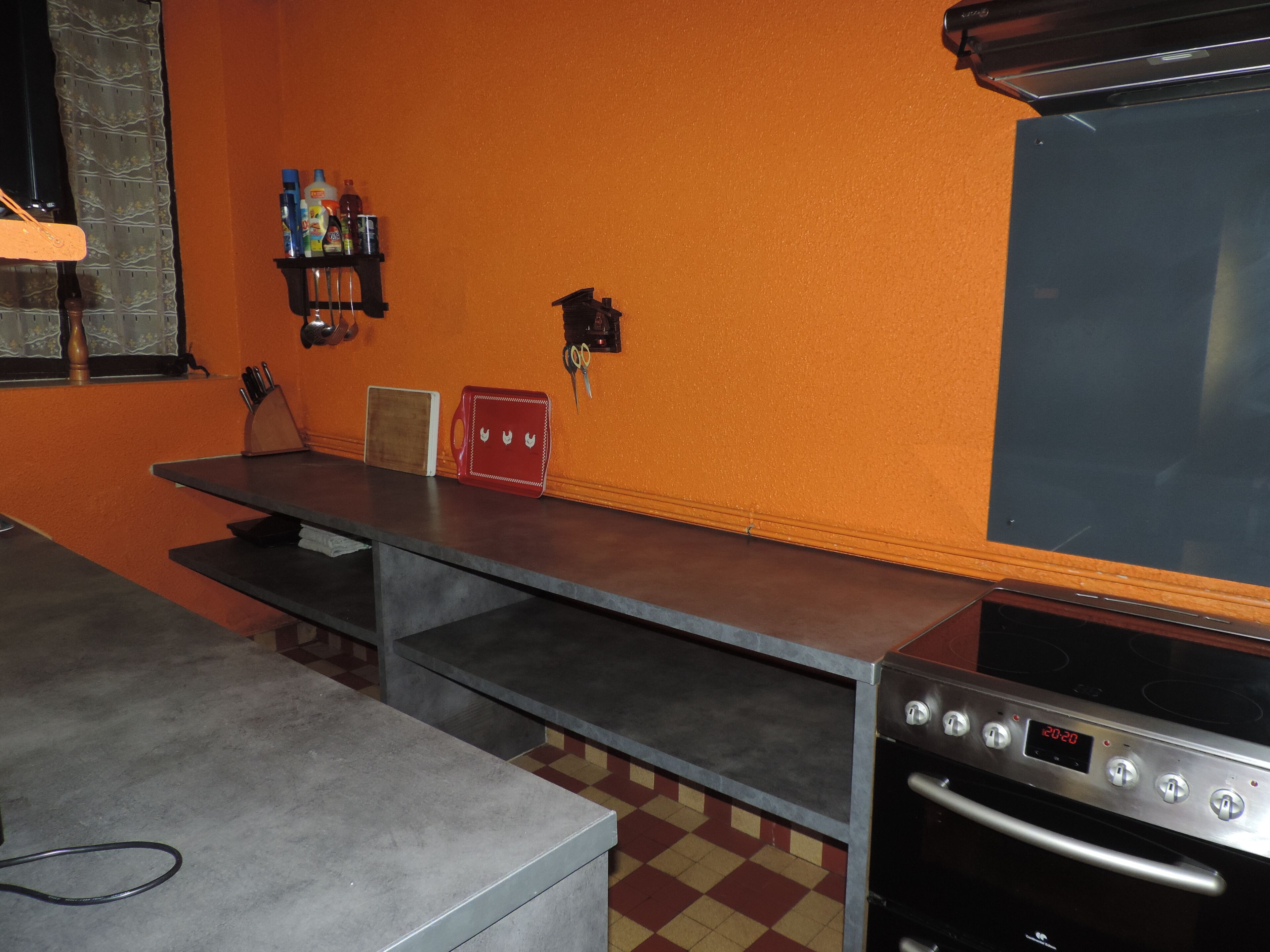 Een keuken met een aanrecht, een spoelbak en een fornuis.