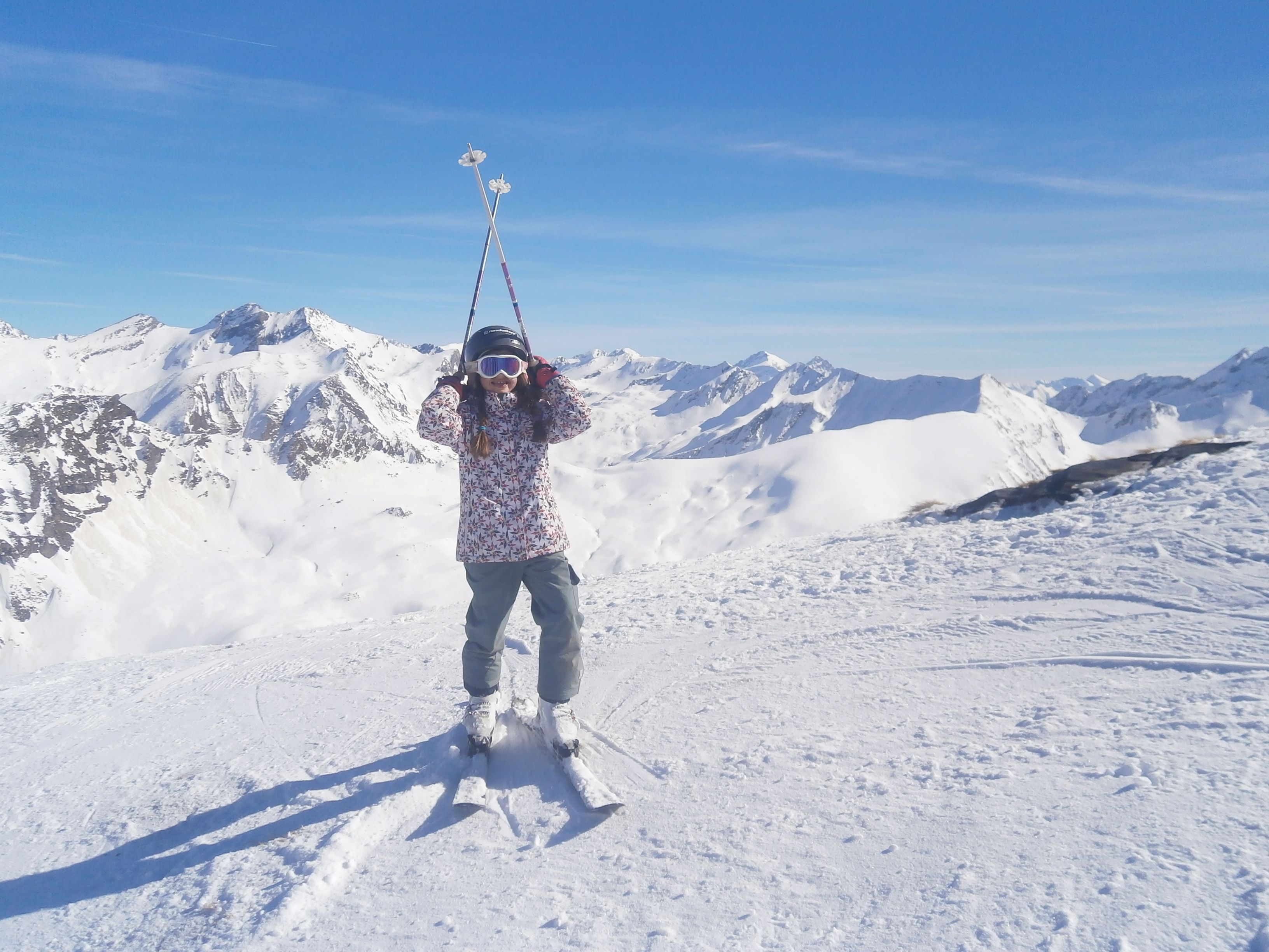 A person skiing on a snowy mountain with a clear sky.
