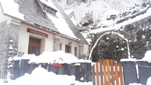 A stone building with a wooden door and a sign that reads "le barbajou". - Le Barbajou (Aragnouet)