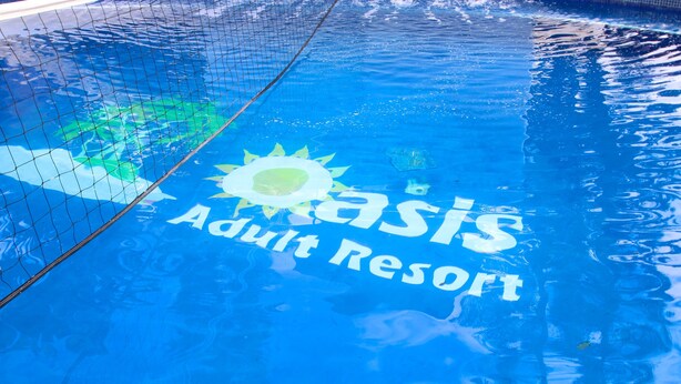 A pool with the text "Oasis Adult Resort" and a sun graphic. - Oasis Adult Resort (Puerto Plata)