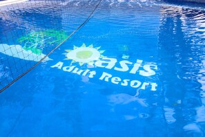 A pool with the text "Oasis Adult Resort" and a sun graphic. - Oasis Adult Resort (Puerto Plata)