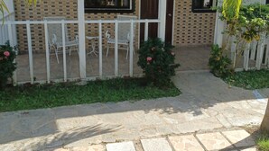 A house with a tiled patio, a covered seating area, and a small garden. - Oasis Adult Resort (Puerto Plata)
