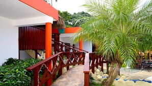 A stone pathway leading to a building with red railings and a palm tree. - Oasis Adult Resort (Puerto Plata)