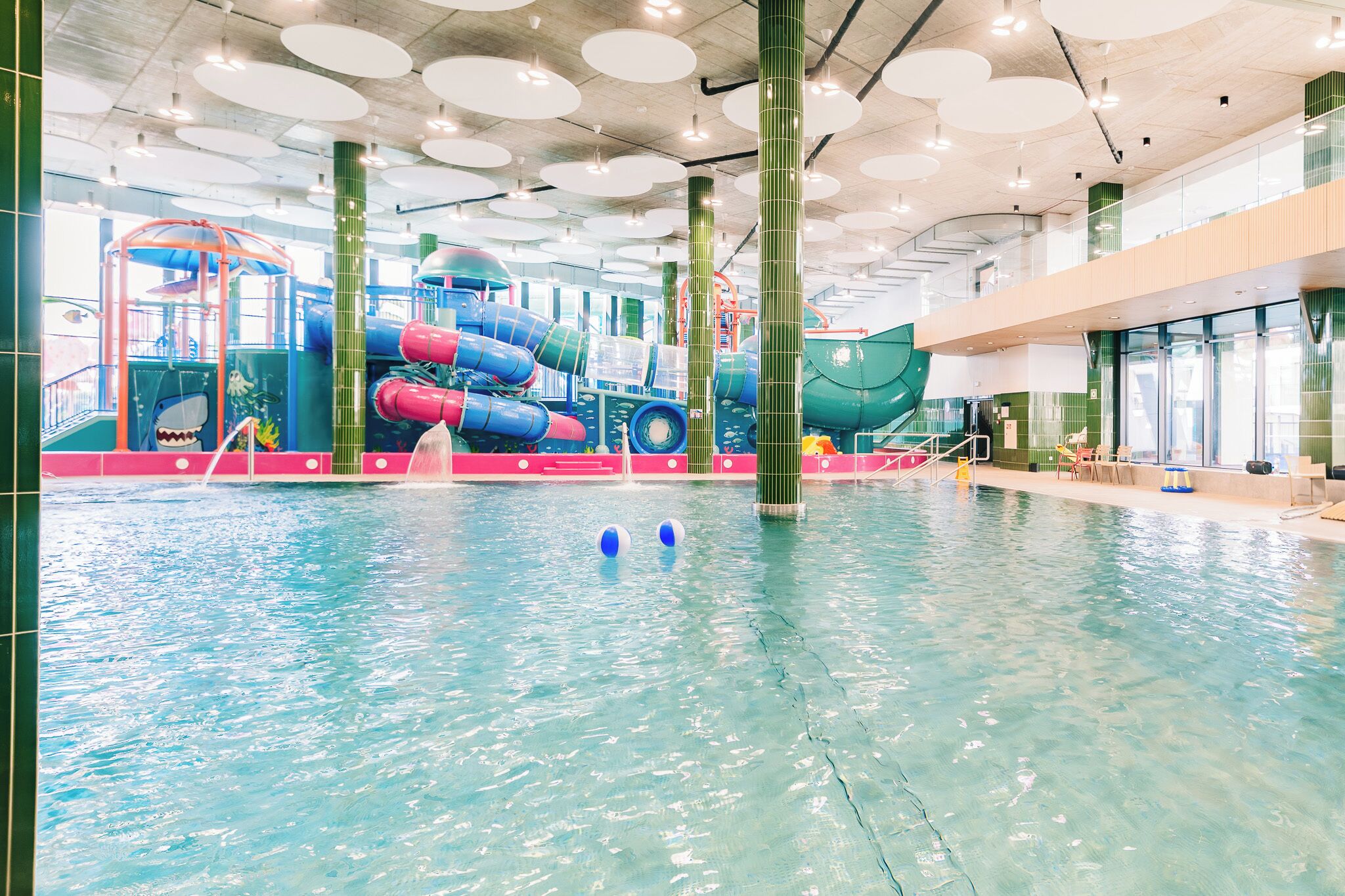 Une piscine intérieure dotée de toboggans et d’aires de jeux.