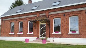 A red brick building with a white trim, large windows, and a covered entrance. - Chambre d'hôtes Coquelicot (Nurlu)