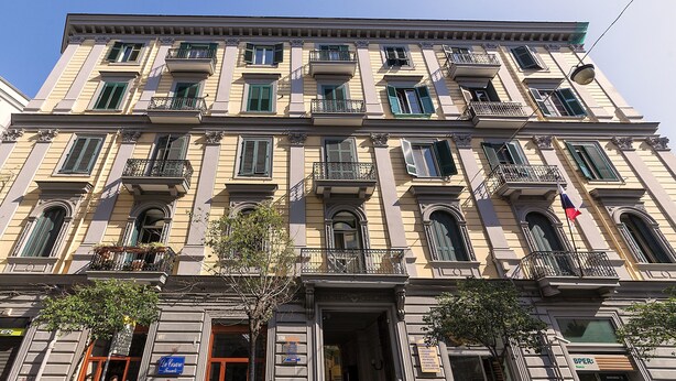 A multi-story building with a classical architectural style, featuring balconies, arched windows, and a central entrance. - Be Italian Flat Duomo 319 (Naples)
