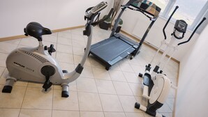 Une salle de sport à domicile équipée d’un vélo elliptique, d’un tapis de course et d’un vélo d’appartement.