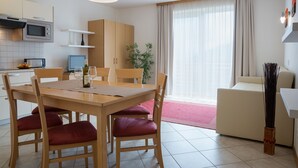 Une cuisine moderne avec une table à manger, des chaises et un four à micro-ondes.