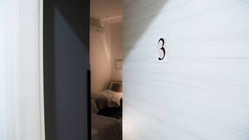 Una habitación con una cama y el número '3' colgado en la pared.