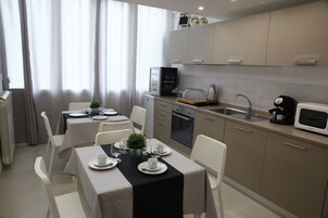 Una cucina moderna con zona pranzo, dotata di microonde, macchina del caffè e piccolo frigorifero.