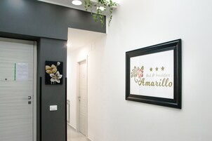 Un corridoio con un cartello incorniciato appeso al muro che riporta la scritta “Bed & breakfast Amarillo”.