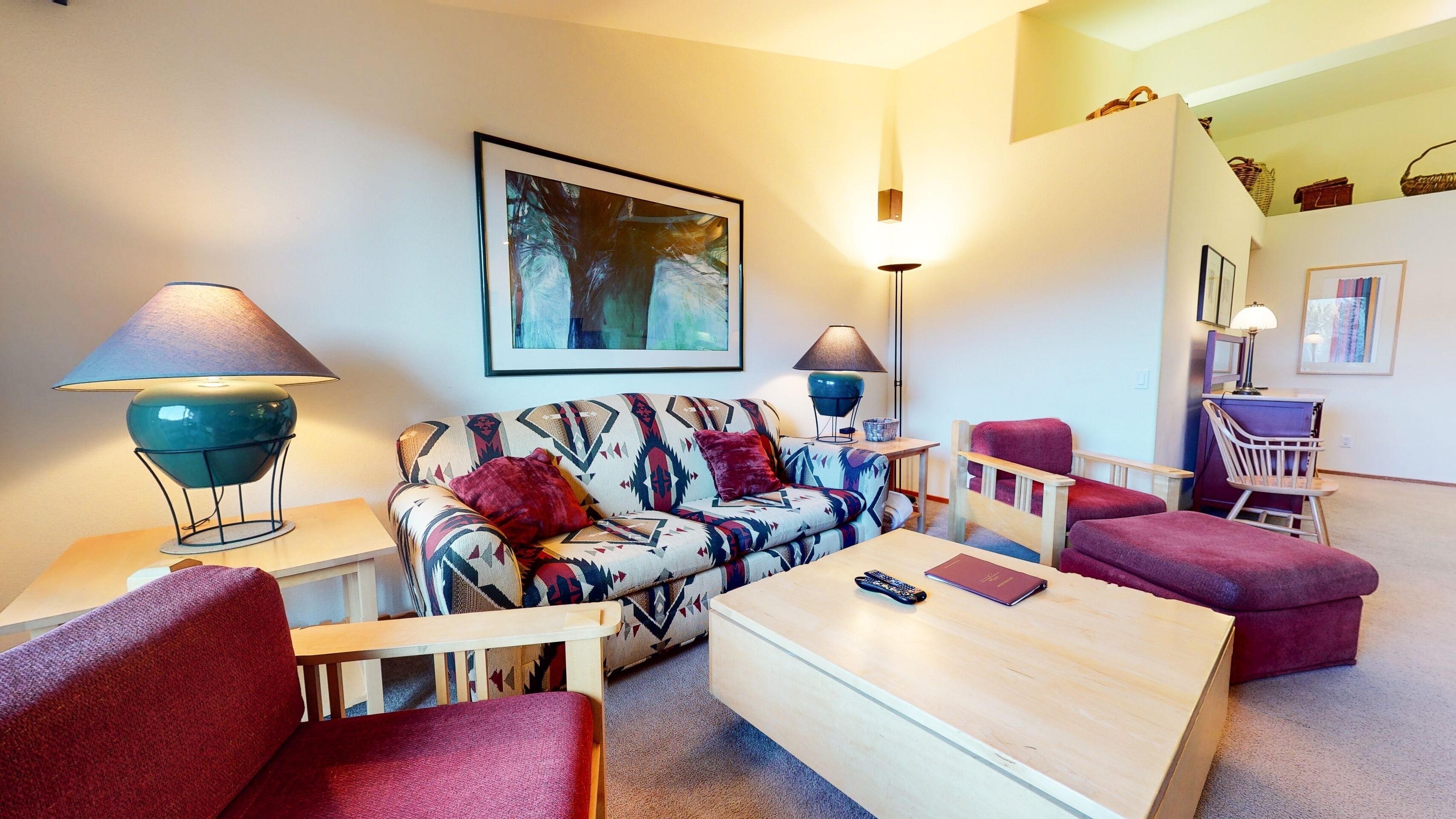 Ein Wohnzimmer mit einer Couch, Sesseln, einem Couchtisch und zwei Stehlampen.