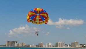 A parasail with a multicolored canopy flying over a coastal cityscape. - Sea Cloisters 302b 2 Bedroom Condo by RedAwning (North Myrtle Beach)