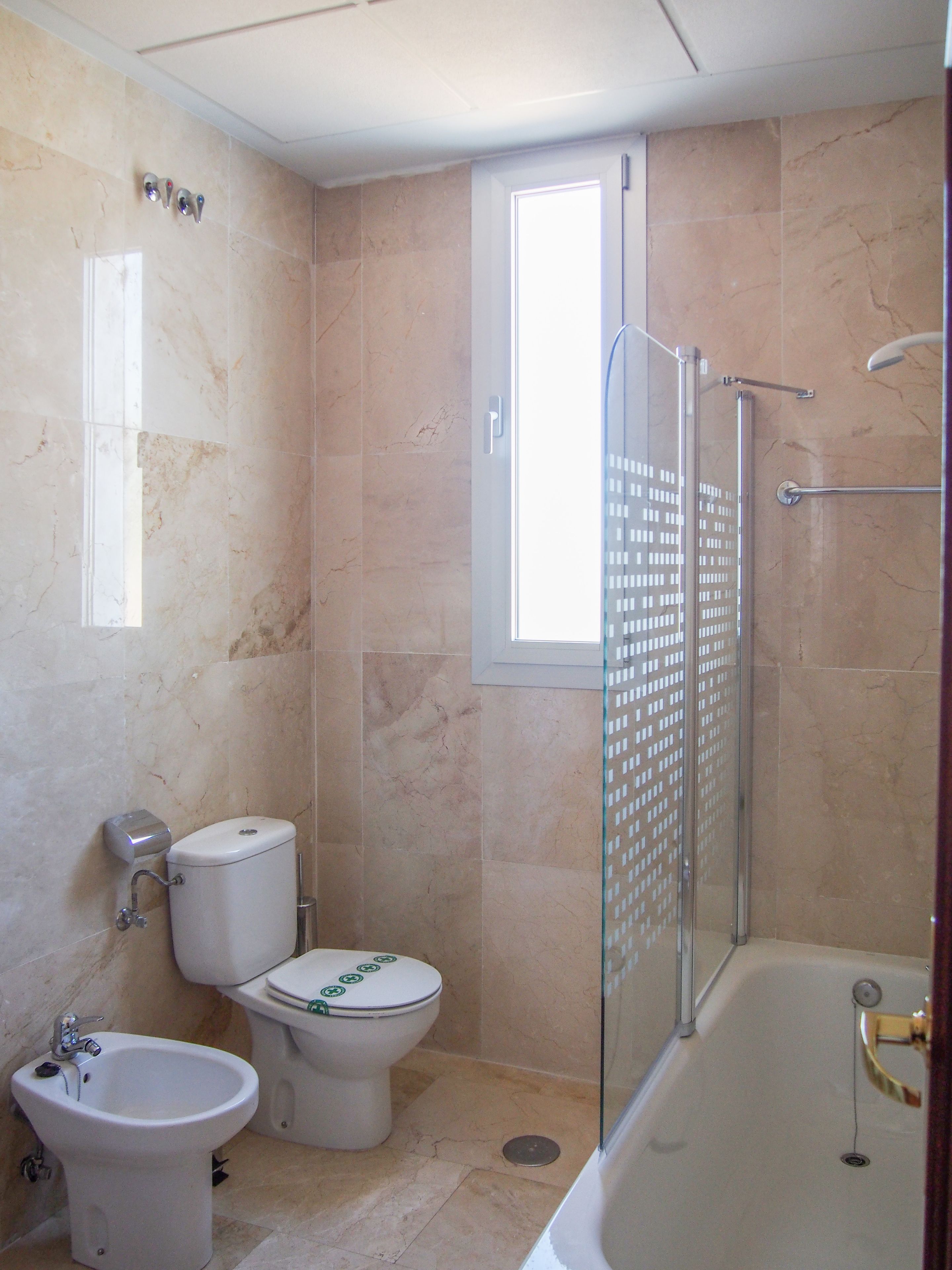 Un baño con inodoro, bidé y bañera.
