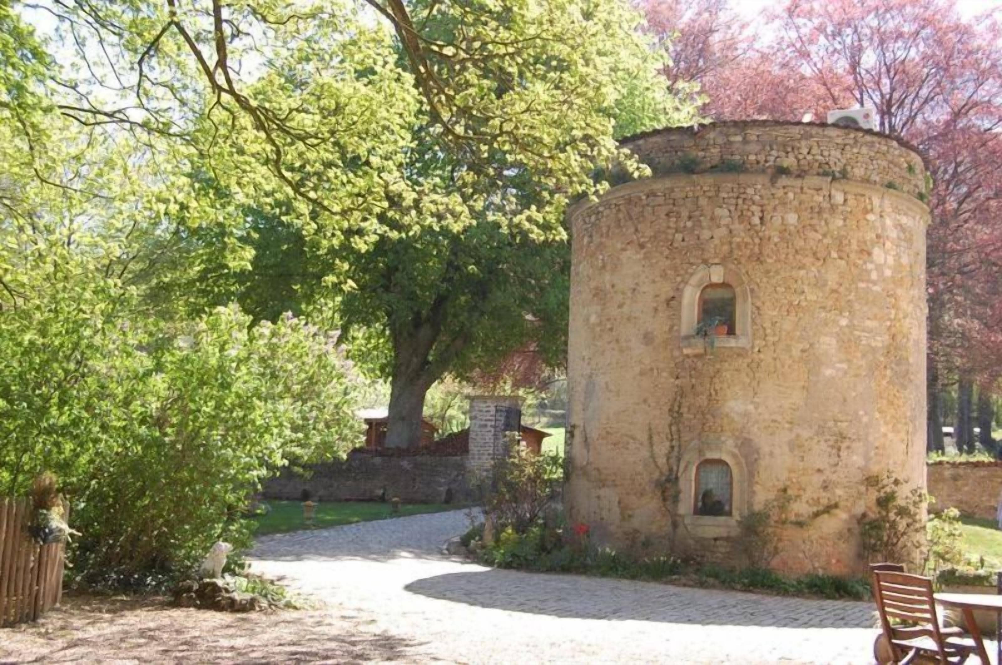 Una torre de piedra con base circular, una pequeña ventana y una puerta.