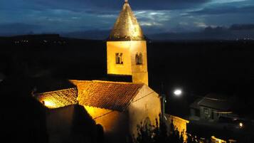 A church with a bell tower, a tiled roof, and a small window.