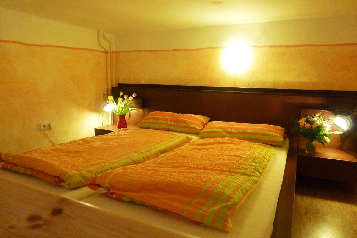 Une chambre d’hôtel avec un lit, deux tables de chevet et deux lampes.