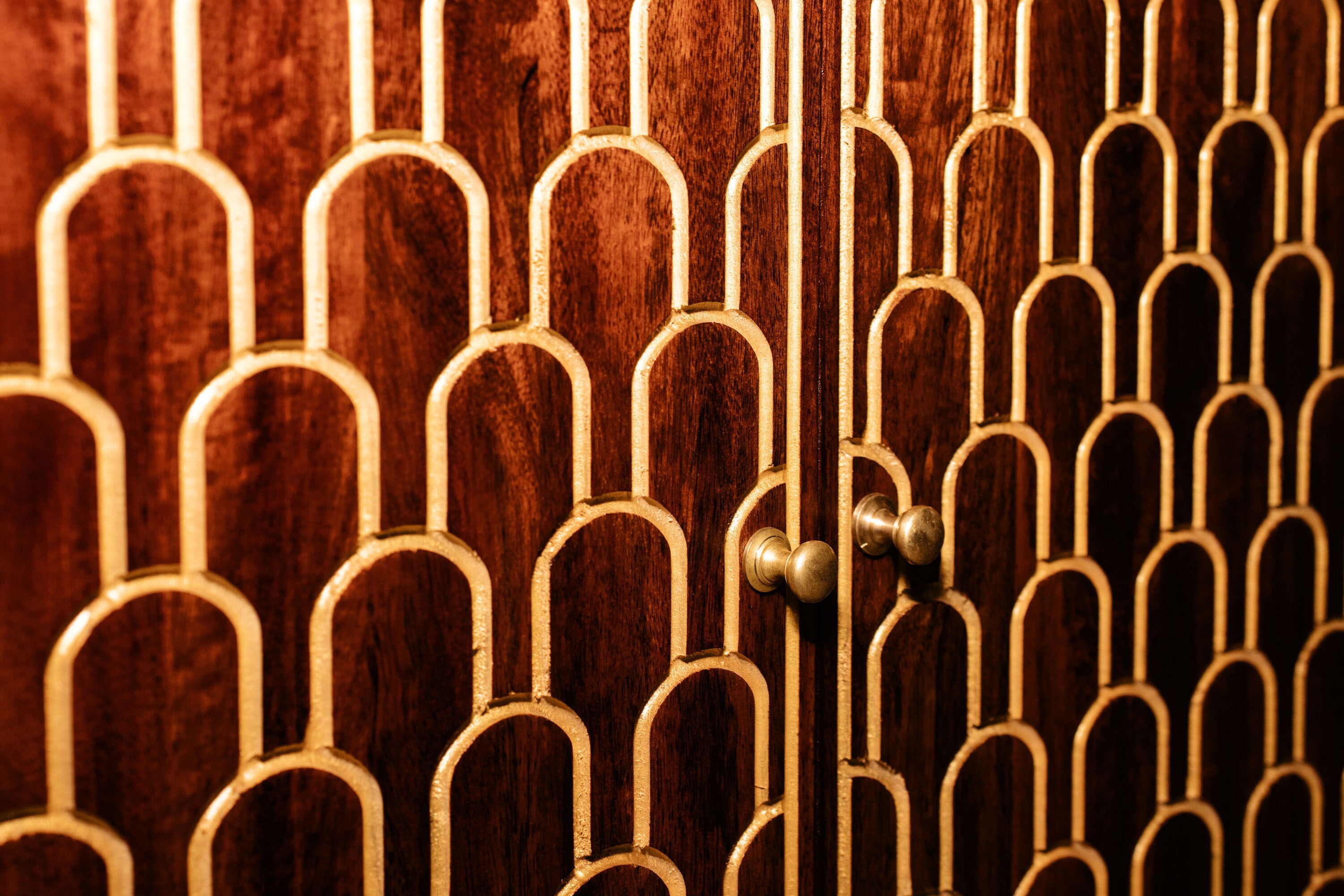 Primer plano de una puerta de madera con una celosía metálica de seguridad.