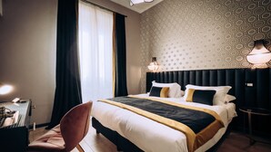 A hotel room with a bed, a desk with a keyboard, a chair, and a lamp. - Mi Hotel Home (Rome)