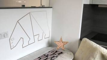 A modern room with a marble table, a fluffy chair, a star-shaped light, and a wall art piece.