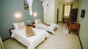 A hotel room with two beds, a desk, and a chair. - Keys Hotel Mbokomu Branch (Moshi)