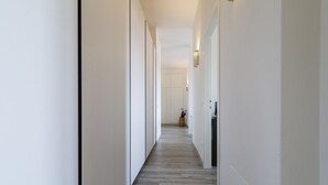 A narrow hallway with a wooden floor and white walls. - Visarno Arena Apartment (Florence)