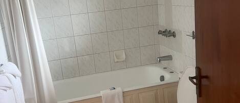Kylpyhuone, jossa on kylpyamme, wc ja suihku.