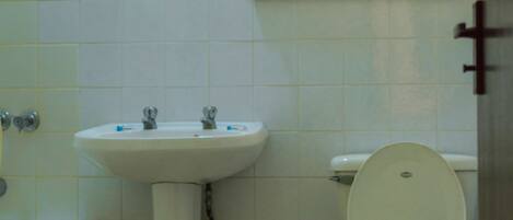 A bathroom with a sink, toilet, and a mirror.