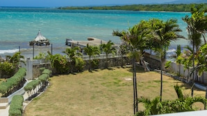 A coastal view with a clear sky, a sandy beach, and a small pavilion. - Seacrest Beach Hotel (St. Ann's Bay)
