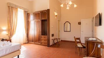 Ein Hotelzimmer mit Bett, Schrank, Schreibtisch, Stuhl und Spiegel.