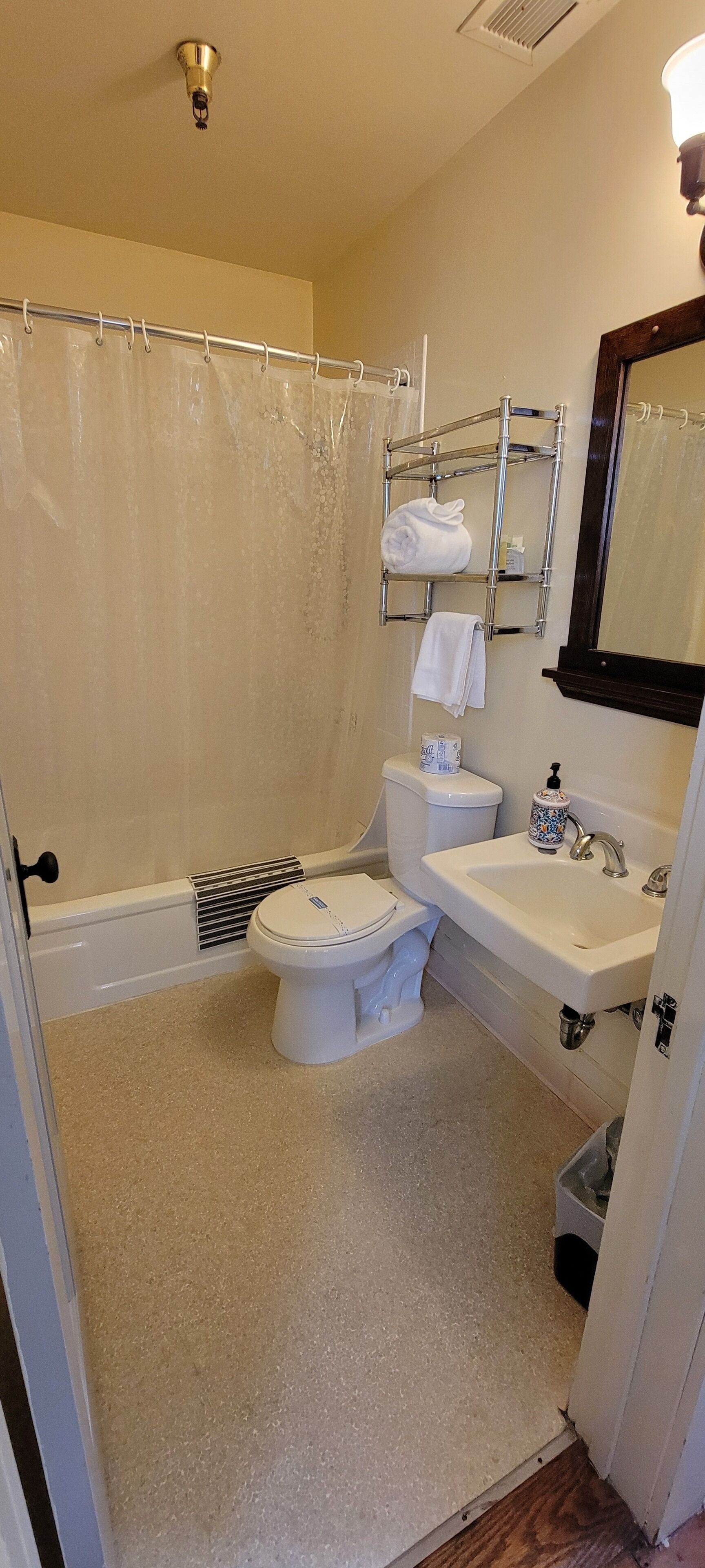 Une salle de bain comprenant des toilettes, un lavabo et un espace douche.