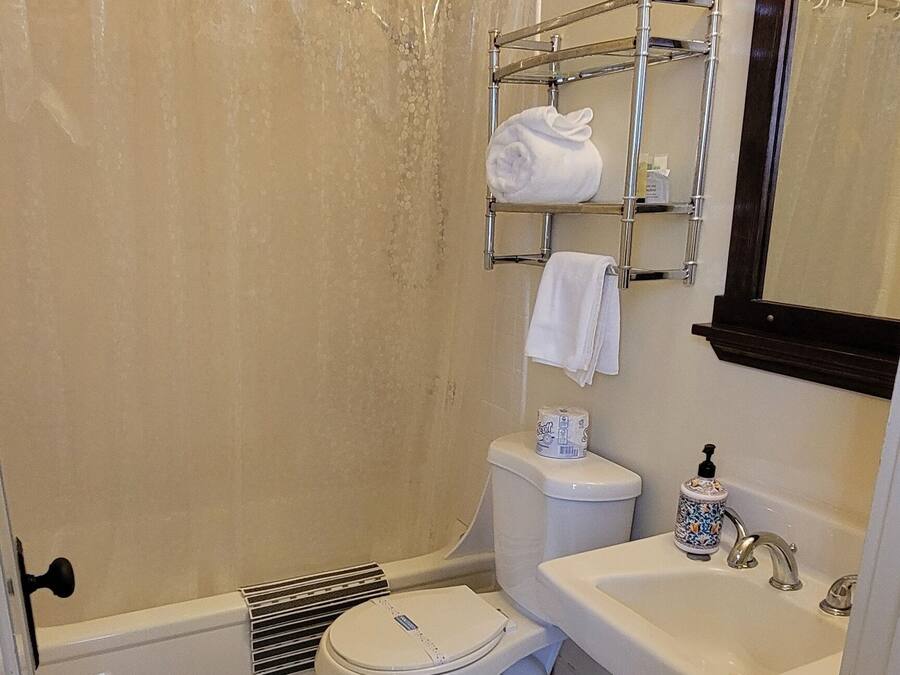 Une salle de bain comprenant des toilettes, un lavabo et un espace douche.