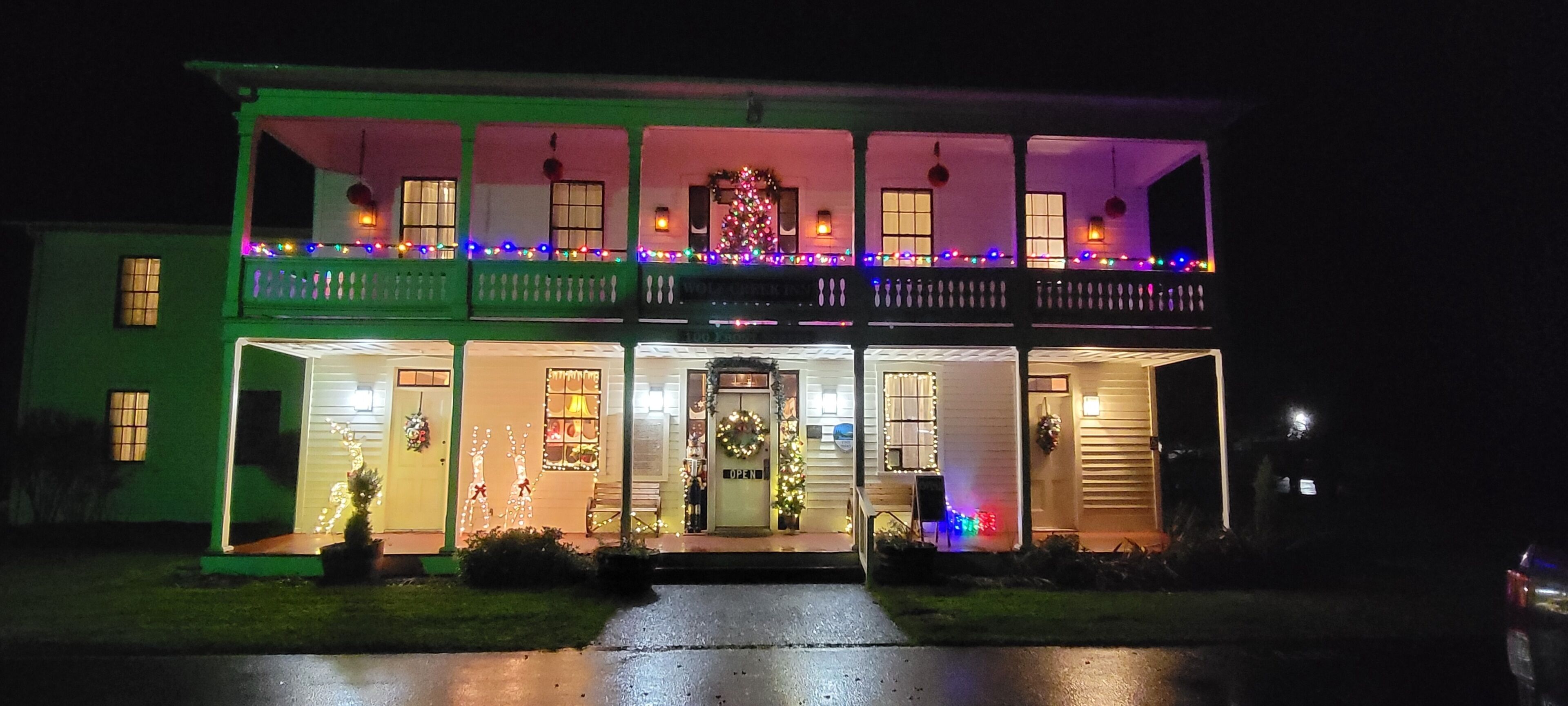 Un edificio de dos pisos con un balcón, iluminado por luces de colores.