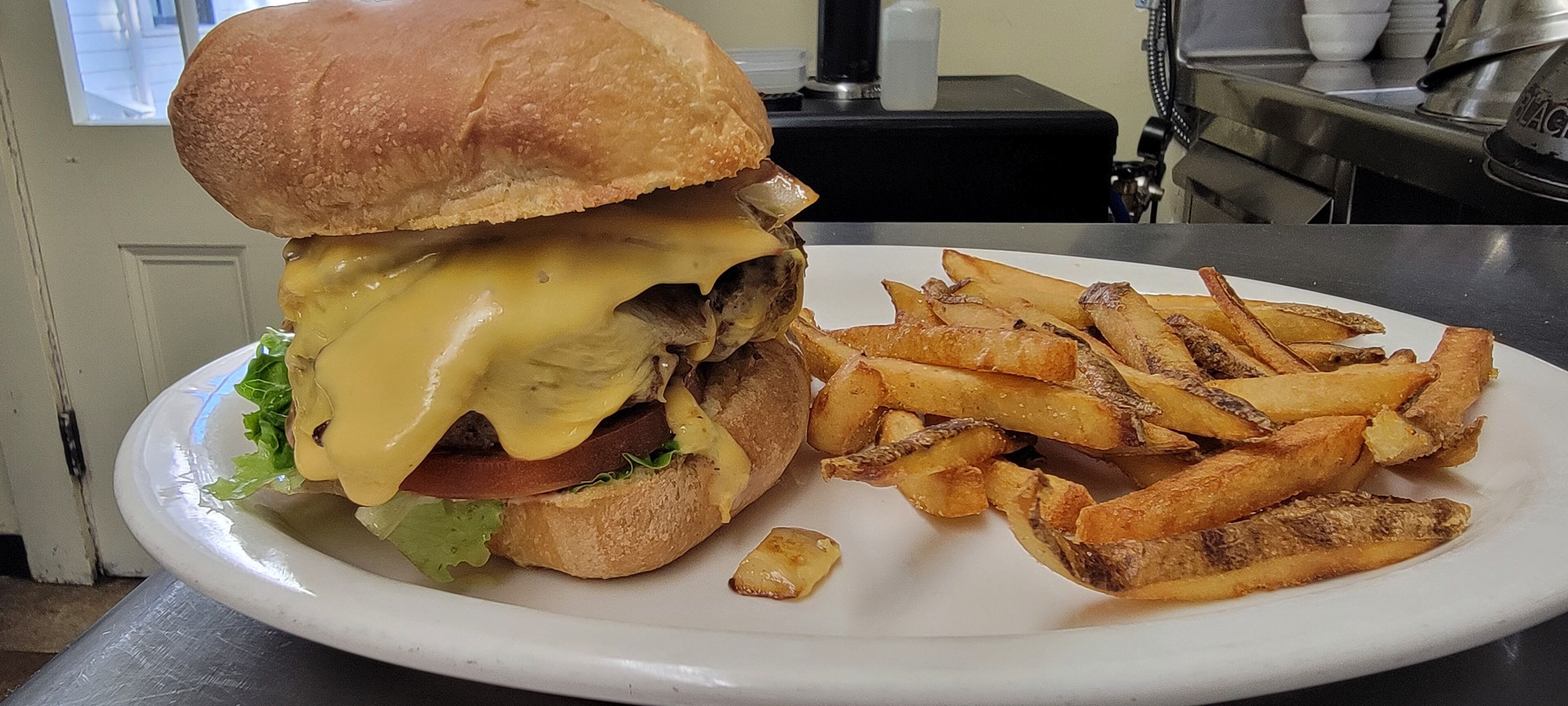 Un plato con una hamburguesa con queso y papas fritas.