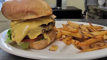 Un plato con una hamburguesa con queso y papas fritas.