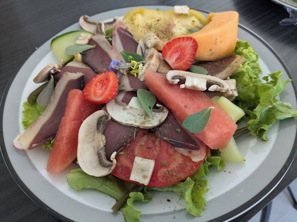 Un plato de comida con varias verduras y una rebanada de queso.