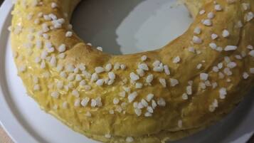 Un pastelito redondo con azúcar blanca granulada sobre un plato blanco.