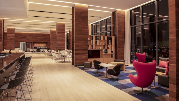 Ein stilvoller Lounge-Bereich mit Bar, Sitzgelegenheiten und einem großen Fenster.
