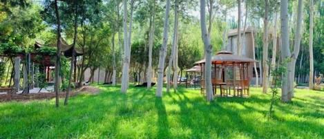 A park with trees, a gazebo, and a wooden structure.