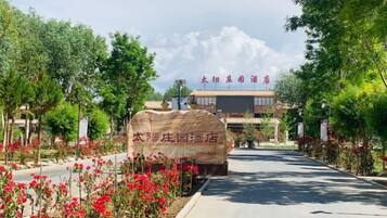 Welcome to our hotel, featuring a traditional Chinese sign and a modern building with a flat roof and windows.