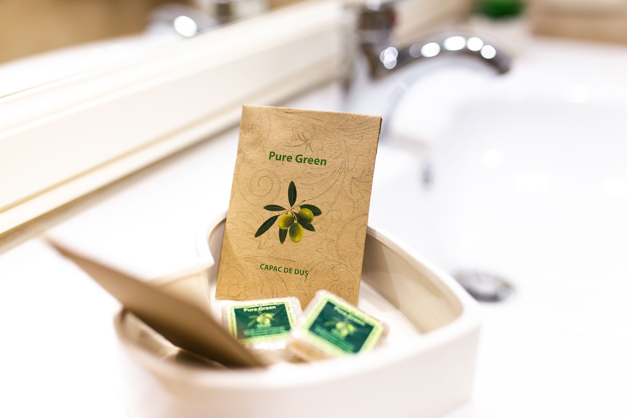 A bathroom sink with a bottle of Pure Green soap and a brown paper bag labeled "Pure Green" and "Capac de Dus".