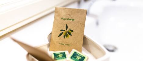 A bathroom sink with a bottle of Pure Green soap and a brown paper bag labeled "Pure Green" and "Capac de Dus".