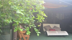 A room with a bed, a small table, and a window. - Hospedagem Praia de Piratininga (Niteroi)