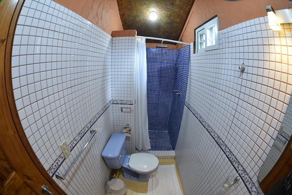 A bathroom with a shower, toilet, and sink.