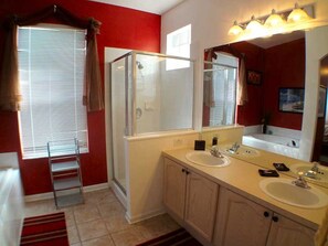A bathroom with two sinks, a shower, and a large mirror. - 4BR 3BA Home in Windsor Palms by CV-8112 (Kissimmee)
